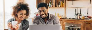 black couple at kitchen table on computer